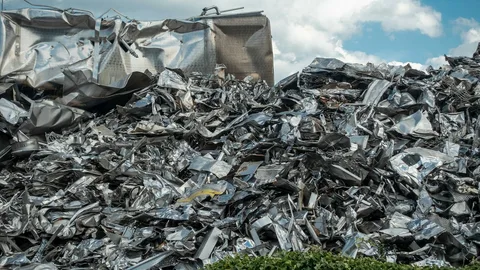 scrap metal recycling yard with sorted metals and workers loading materials for resale in 2026 guide
