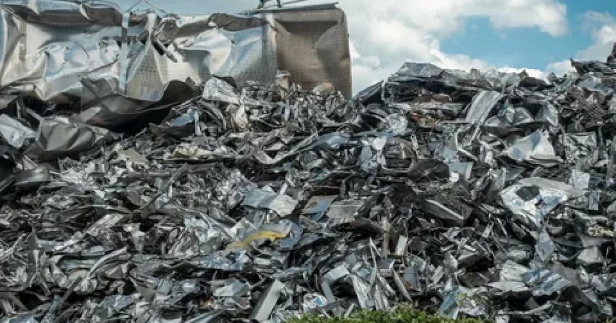 scrap metal recycling yard with sorted metals and workers loading materials for resale in 2026 guide